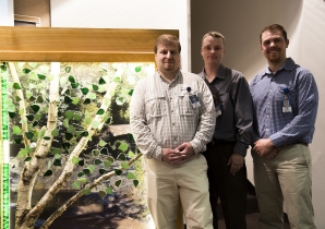 St. Luke's ICU nurses Jeremy Nelson, Pete Boyechko and David Johnson stand next to the Wall of Heroes memorial they created.